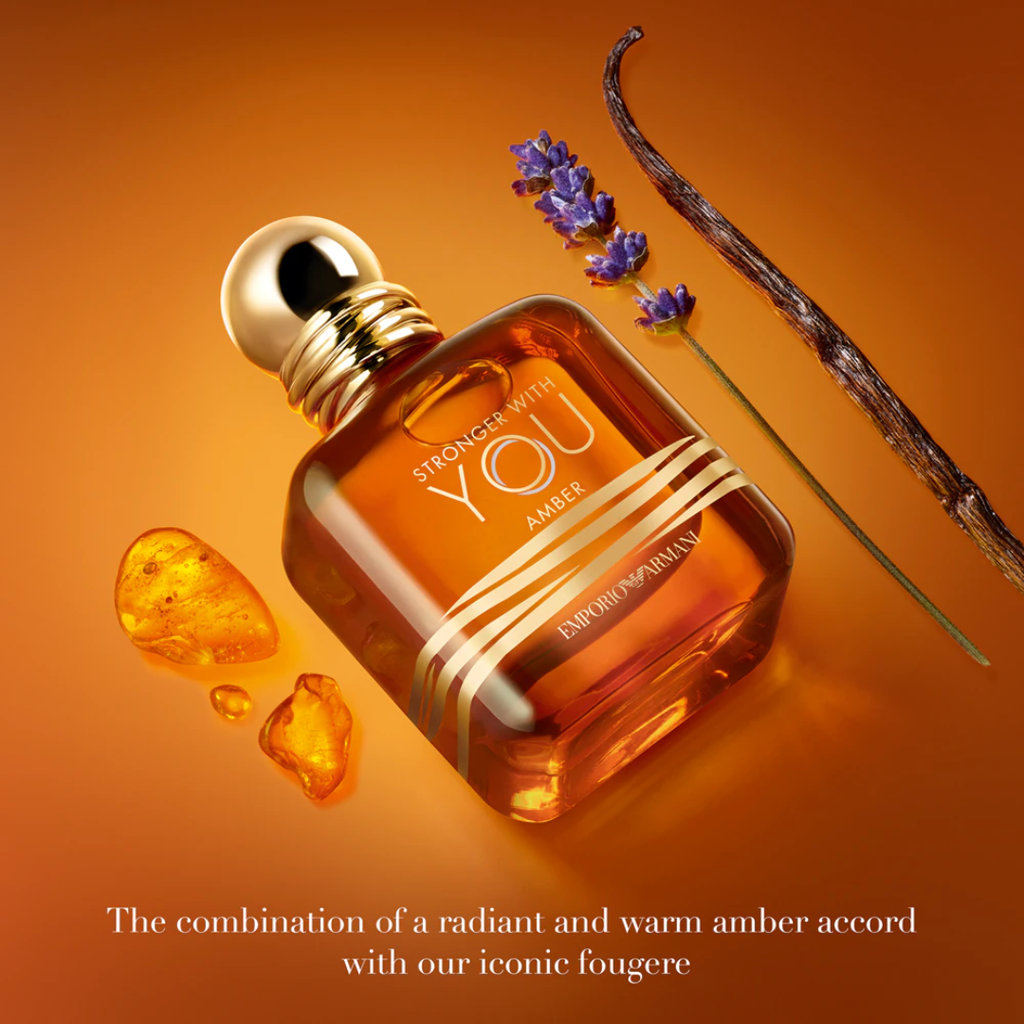 Lifestyle flat-lay of Emporio Armani Stronger With You Amber Eau de Parfum 100 ml bottle captured for Fragrance Emporium. The warm amber tone and glowing light highlight its rich composition of bourbon vanilla, spicy amber, and lavender for a bold, modern look.
