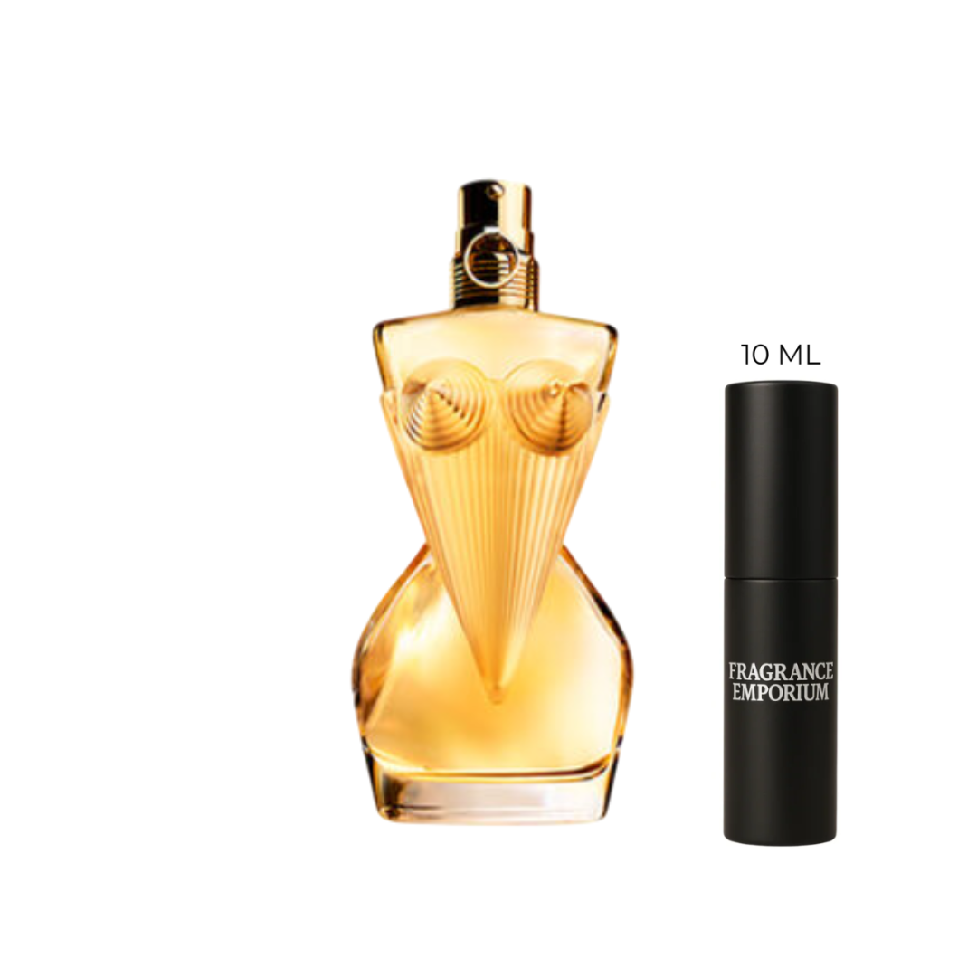 Angled shot of Jean Paul Gaultier Divine Eau de Parfum bottle beside a 10 ml sample vial, highlighting its golden armor-like design. The fragrance mixes red berries, jasmine and meringue over a musk and patchouli base — a new elegant women’s perfume available in 10 ml luxury decants from Fragrance Emporium.